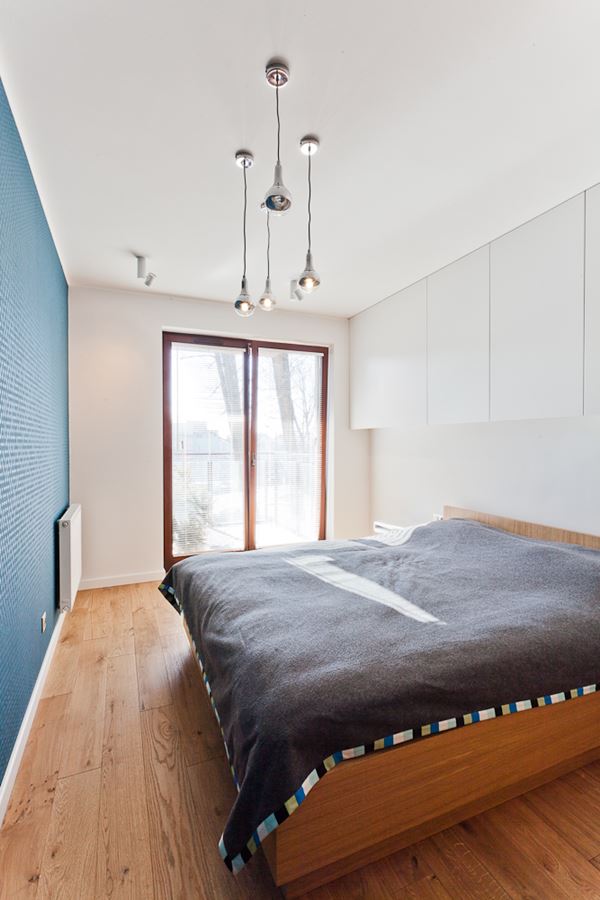 Minimalistyczna sypialnia z niebieskim akcentem