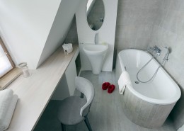 Aranżacja szarej łazienki z toaletką na poddaszu