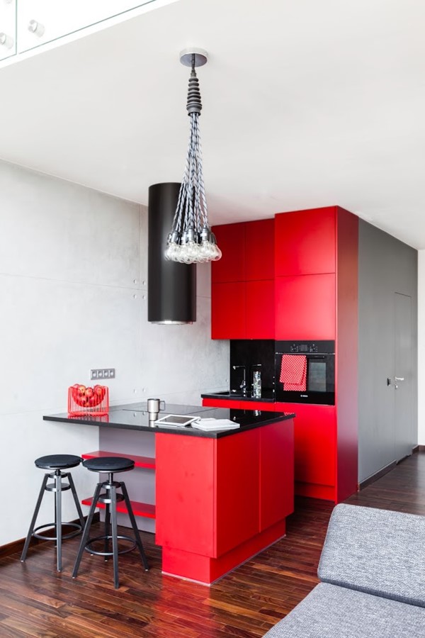 Czerwona otwarta kuchnia w salonie styl nowoczesny
