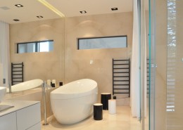 Szkło i kamień w przestronnej łazience w nowoczesnym stylu