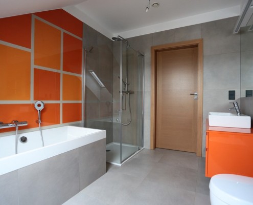 Nowoczesna łazienka na poddaszu z pomarańczowym akcentem