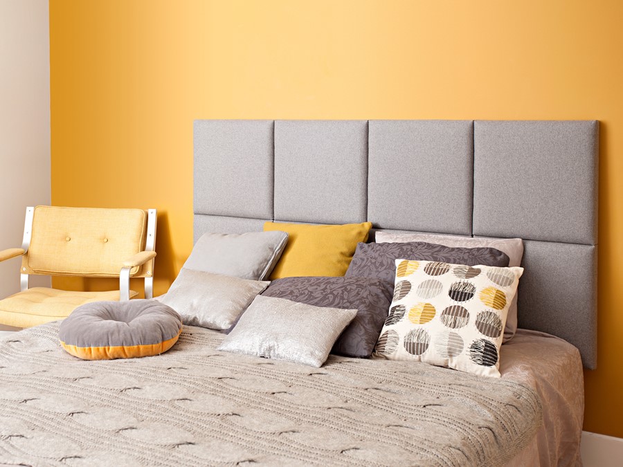 Mała sypialnia w ciepłych barwach tapicerowane panele