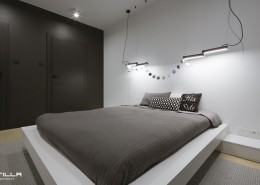 Minimalistyczna sypialnia z nowoczesnym oświetleniem Tilla Architects