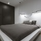 Minimalistyczna sypialnia z nowoczesnym oświetleniem Tilla Architects