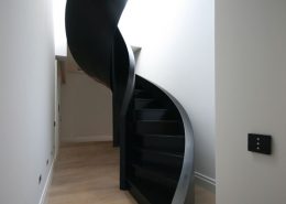 Spiralne, nowoczesne schody w korytarzu