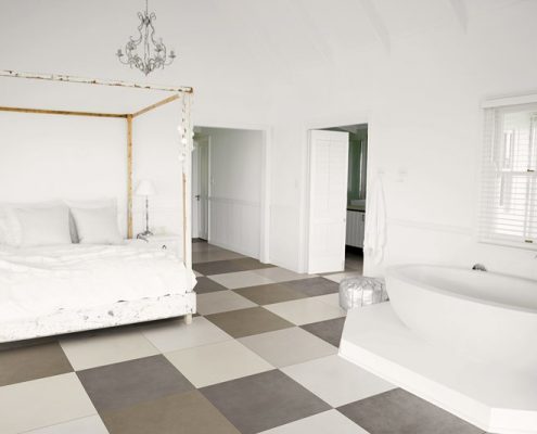 Biała sypialnia z wanną i kontrastującą podłogą