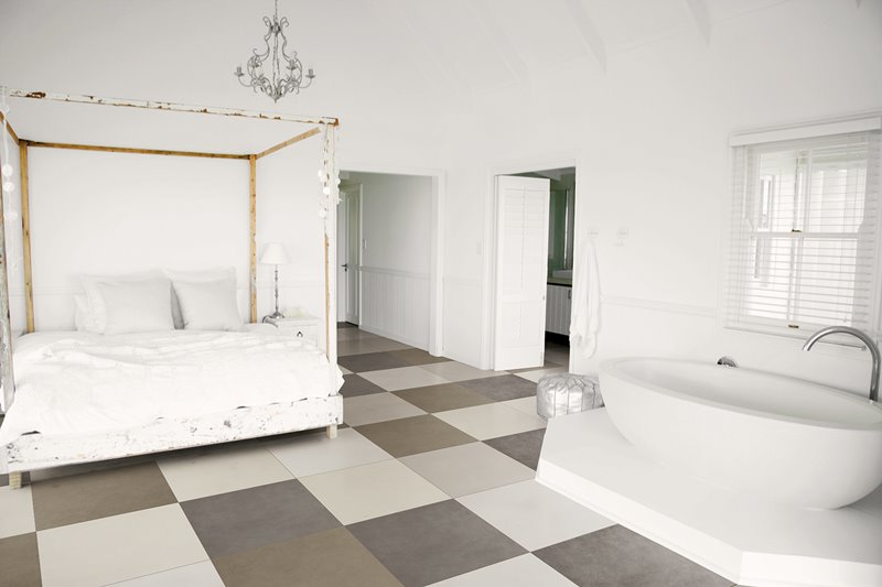 Biała sypialnia z wanną i kontrastującą podłogą