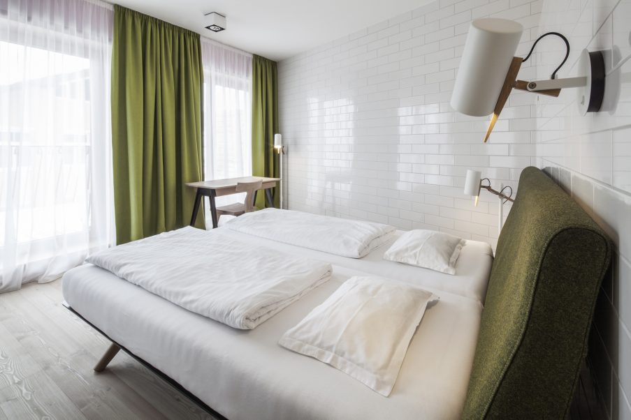 Minimalistyczna sypialnia w bieli i zieleni - hotel Felsenhof