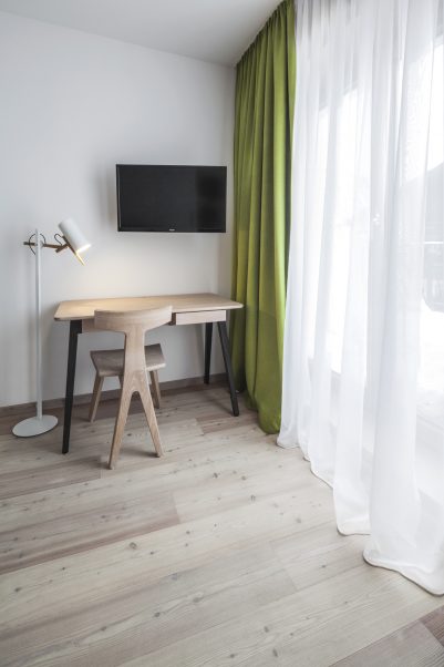 Minimalistyczna sypialnia w bieli i zieleni - hotel Felsenhof