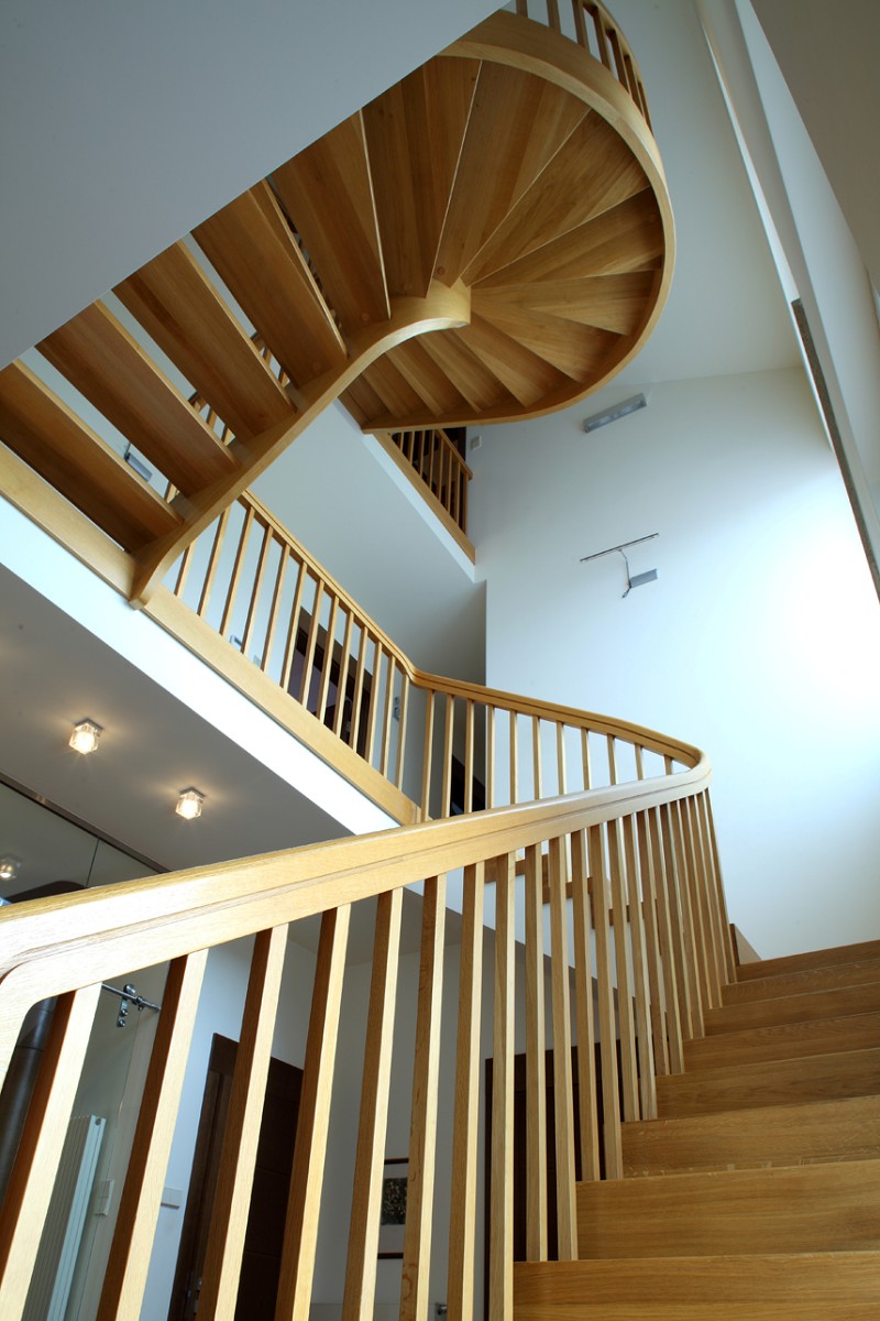 Drewniane, półspiralne schody w przedpokoju